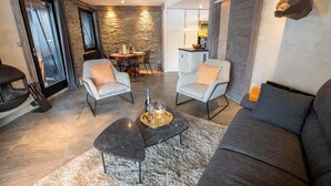Una sala de estar moderna con chimenea, dos sillones, un sofá y un comedor.