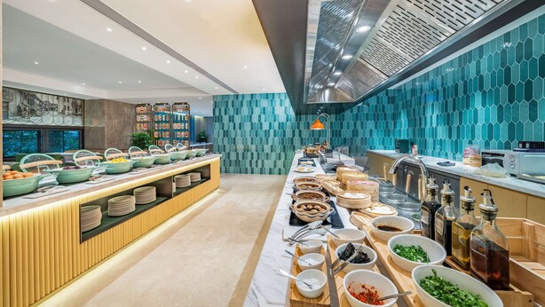A buffet setup with various food items and condiments. - Hilton Garden Inn Chengdu Kuanzhai Alley (Chengdu)