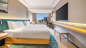 A modern hotel room with a large bed, a desk, a chair, and a TV mounted on the wall. - Hilton Garden Inn Chengdu Kuanzhai Alley (Chengdu)