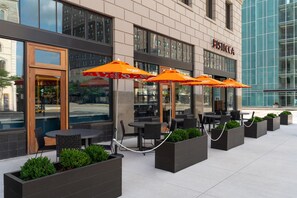 A hotel exterior with outdoor seating, large windows, and a clear view of the street. - Hotel Ardent Dayton Downtown, Tapestry Collection By Hilton (Dayton)