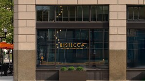 Fachada de edificio con el letrero "BISIECCA ITALIAN STEAKHOUSE" y una maceta pequeña con plantas.