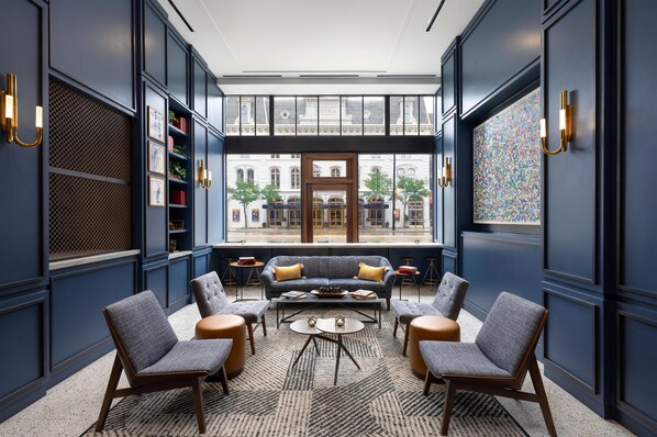 A modern lounge area with seating, bookshelves, and a view of the street. - Hotel Ardent Dayton Downtown, Tapestry Collection By Hilton (Dayton)