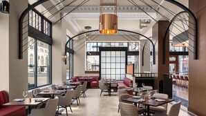 Un restaurante espacioso con techos altos, amplias ventanas y un diseño interior moderno.