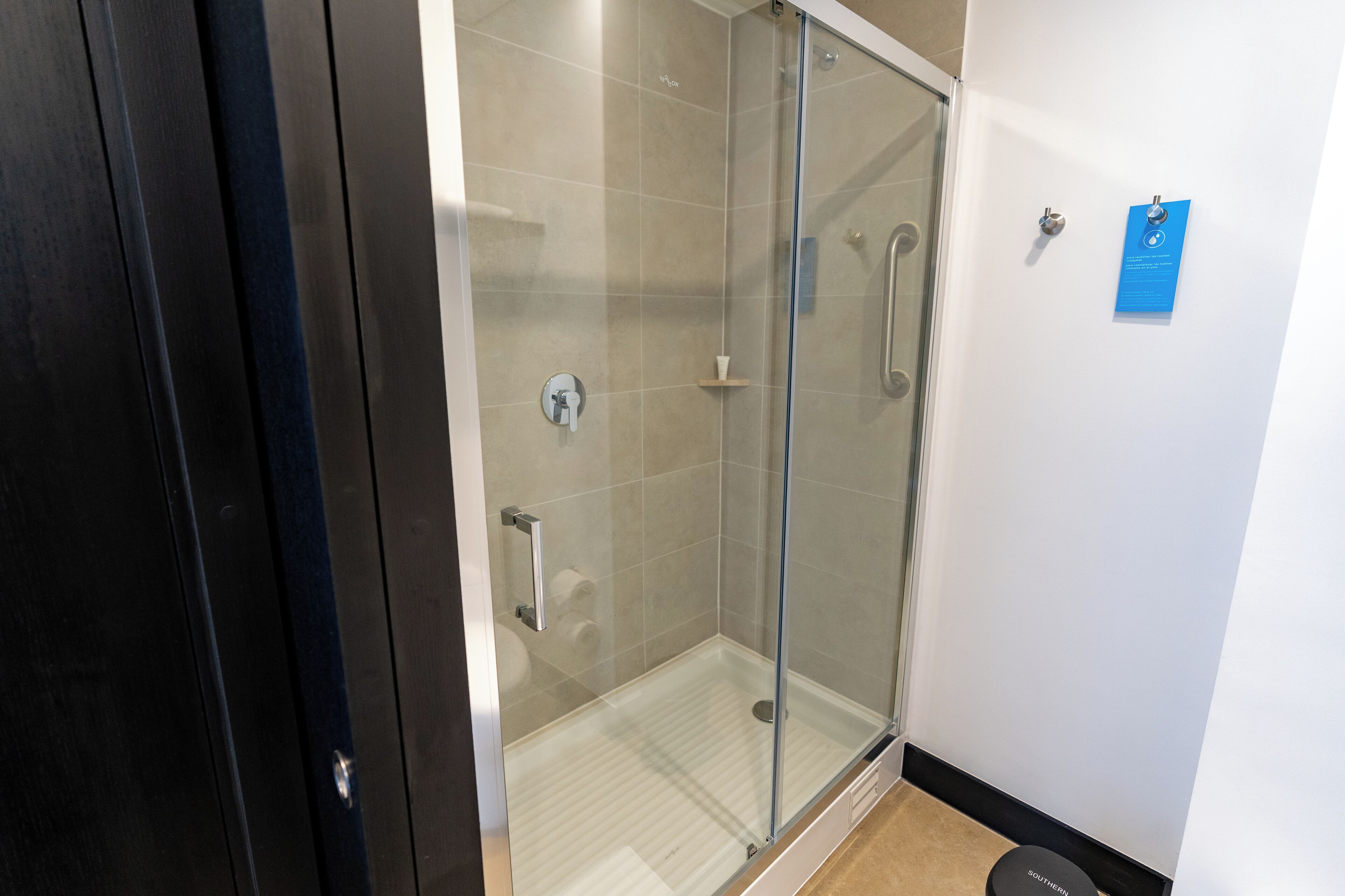 A modern bathroom with a glass shower enclosure, a toilet, and a sink.