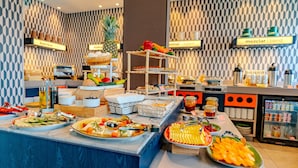 Een buffet met diverse gerechten en een drankstation.