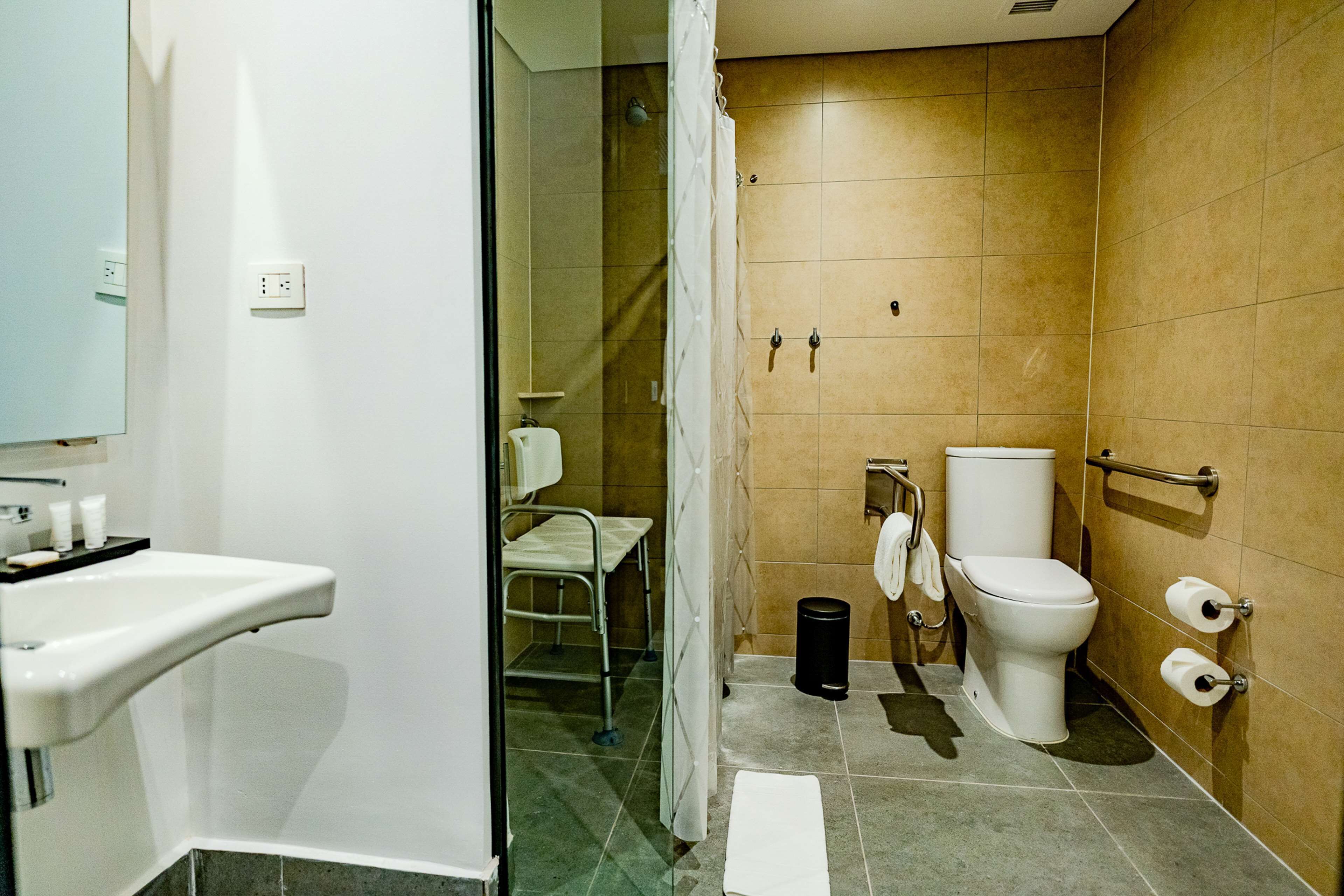 A modern bathroom with a white sink, a toilet, and a shower area.