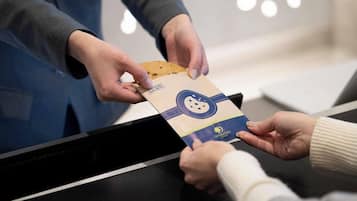 A person handing over a package to another person at a counter.