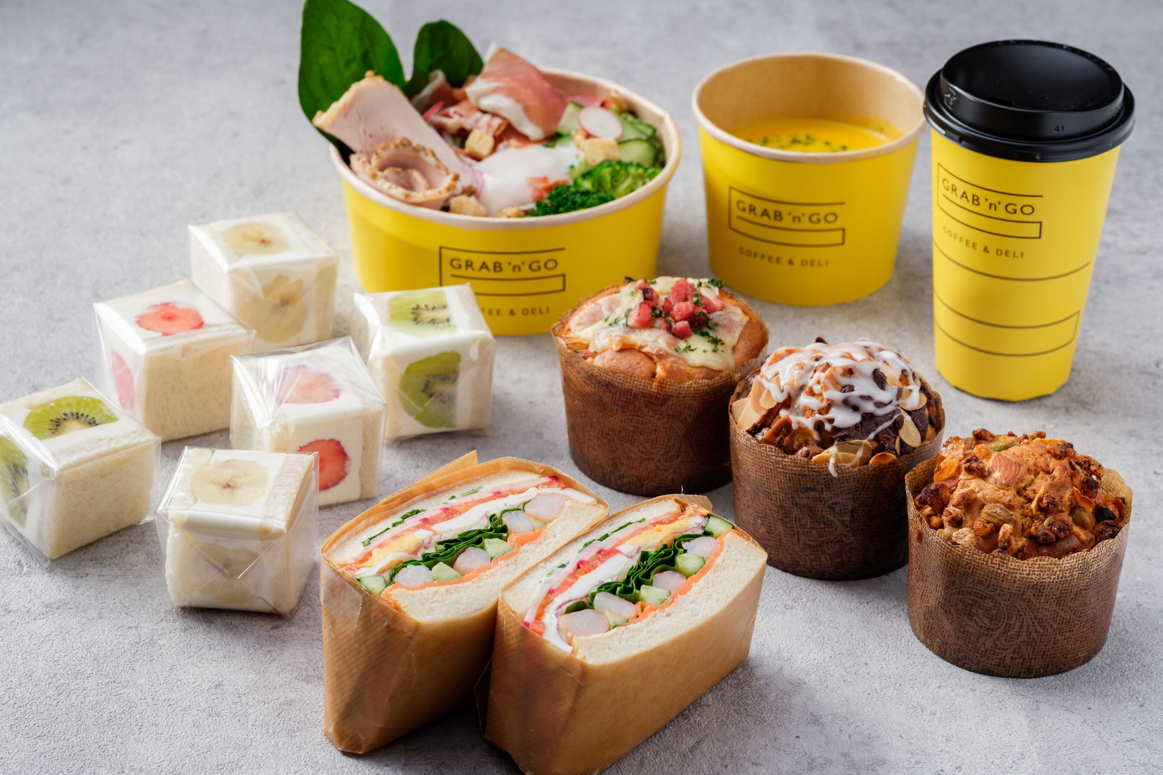 A variety of food items including sandwiches, pastries, and packaged goods, along with yellow branded cups.
