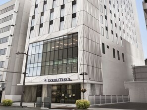 Un bâtiment moderne doté d’une façade en verre et d’une enseigne indiquant « DOUBLETREE ».