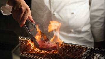A chef grilling meat on a grill.