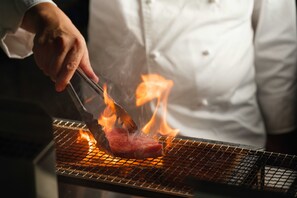 Un chef qui fait griller de la viande sur un barbecue.