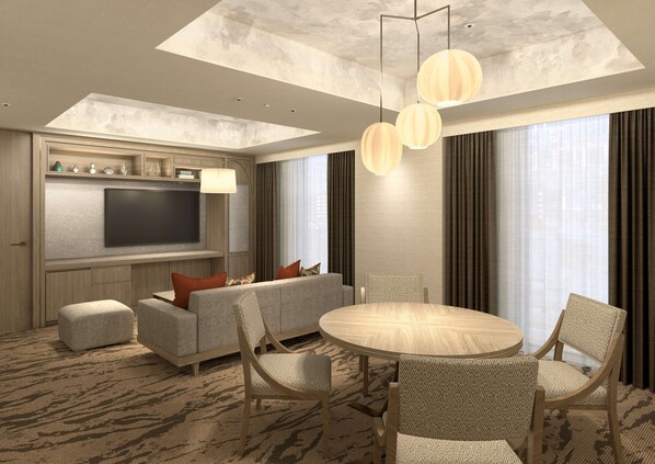 A modern hotel room with a flat-screen TV, a sofa, a dining table, and patterned chairs.