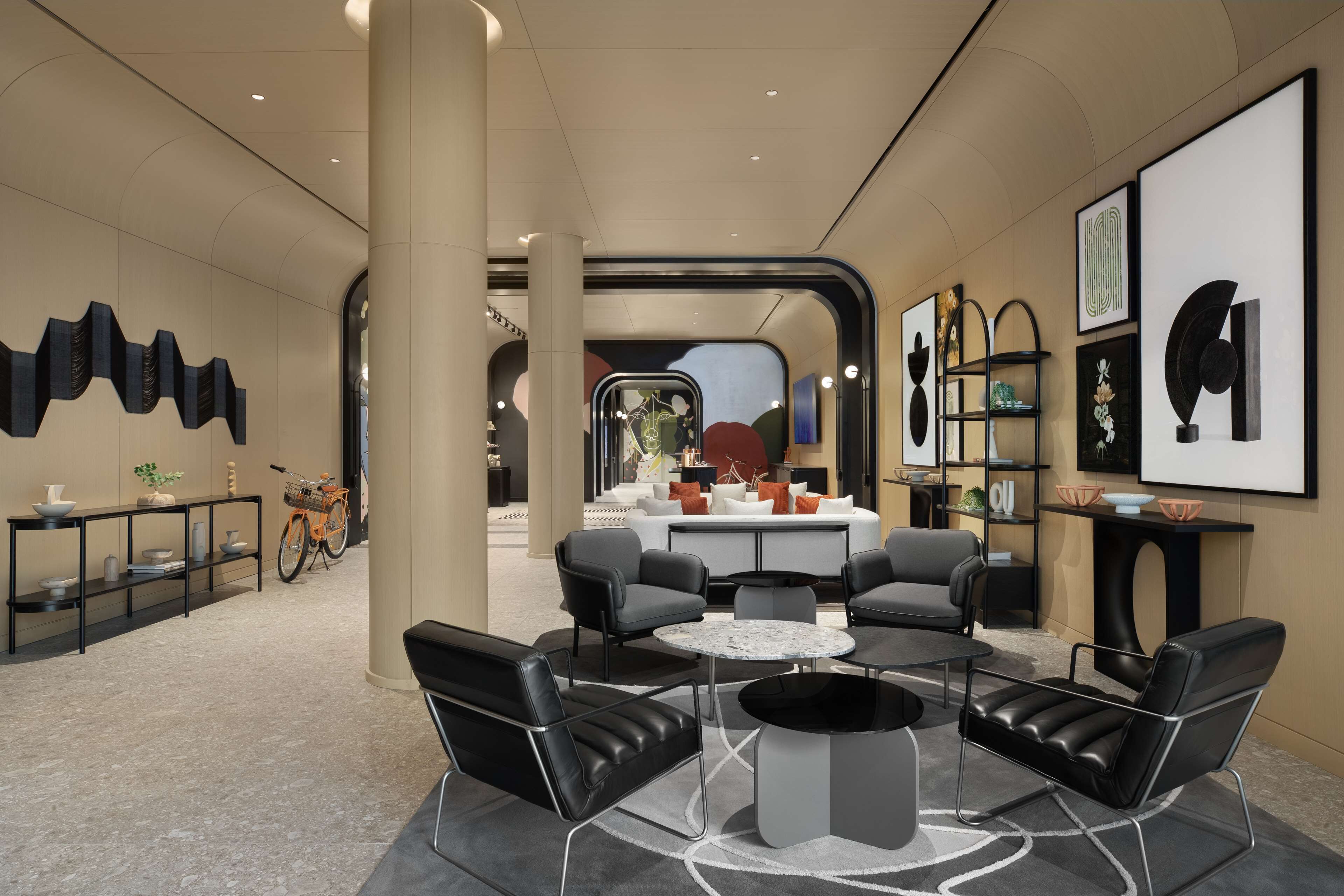 Een moderne hotellobby met een zithoek, een receptiebalie en een groot raam.