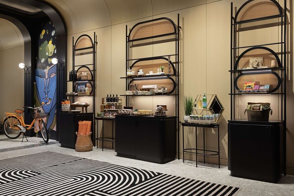 A modern interior with black shelving units displaying various items, a bicycle, and a patterned rug.