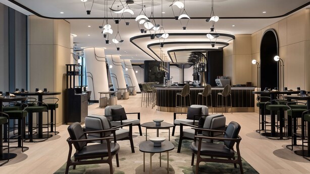 A modern hotel lobby with a central bar area, seating arrangements, and contemporary lighting fixtures. - Canopy By Hilton Toronto Yorkville (Toronto)