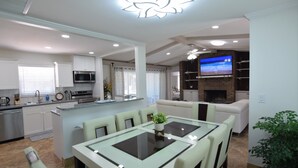 Una cocina moderna con comedor, televisor y chimenea.