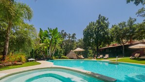 A swimming pool with lounge chairs and umbrellas, surrounded by lush greenery and trees. - Cubo's Finca La Fuente del Pedregal Casa 3 / nature / community pool / free Wi-Fi (Coín)