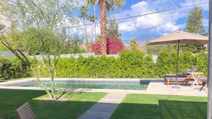 A patio area with outdoor seating, a fire pit, and a swimming pool.