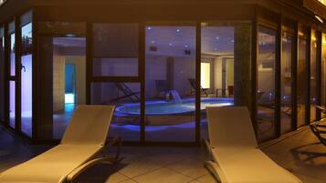 A spa area with a hot tub and lounge chairs.