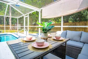 A covered patio with a pool, outdoor seating, and a view of the backyard. - Pets OK! Heated Pool mins to 3 Sisters Spring! (Crystal River)