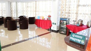 Eine Hotelhalle mit Sitzbereichen, einem Buffet und einem Kühlschrank mit Lebensmitteln.