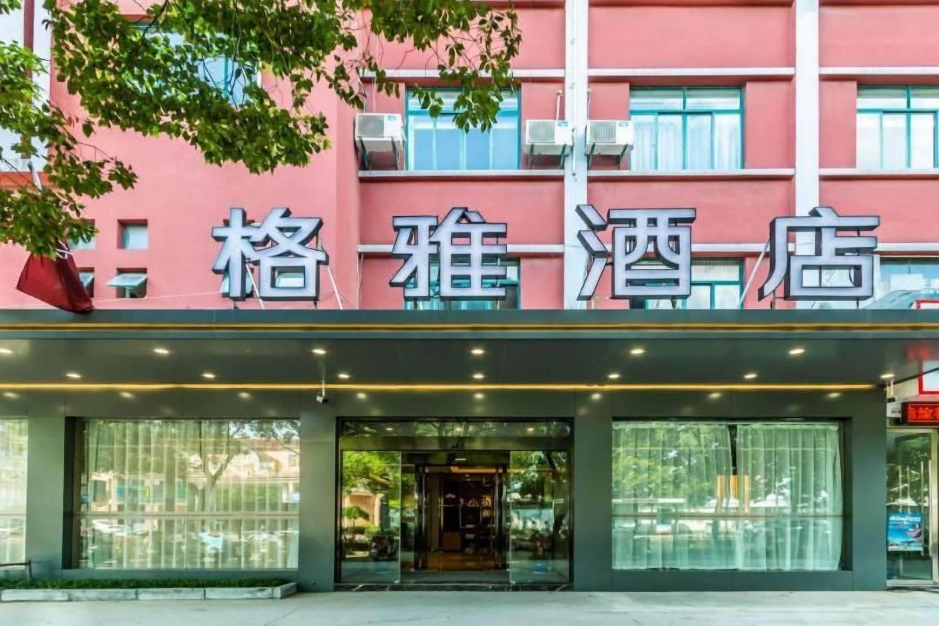 A hotel entrance with a large glass facade and a sign above the door.