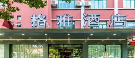 A hotel entrance with a large glass facade and a sign above the door.