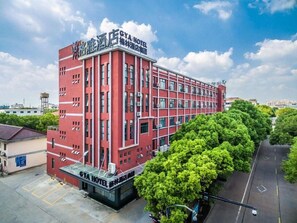 A red hotel building with multiple floors and a flat roof.
