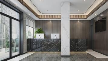 A modern reception area with a marble counter, large windows, and a central pillar.
