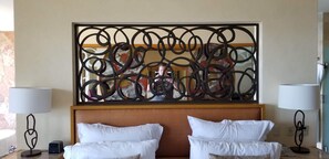 Relax in a stylish space with a large abstract artwork above the bed, two bedside tables, and lamps.