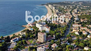 An aerial view of a coastal city with a beach, dense urban area, and a mix of residential and commercial buildings.