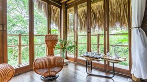 A room with large windows, a wicker chair, a table with cups, and a plant. - Romantic Cabana with view (Armenia)