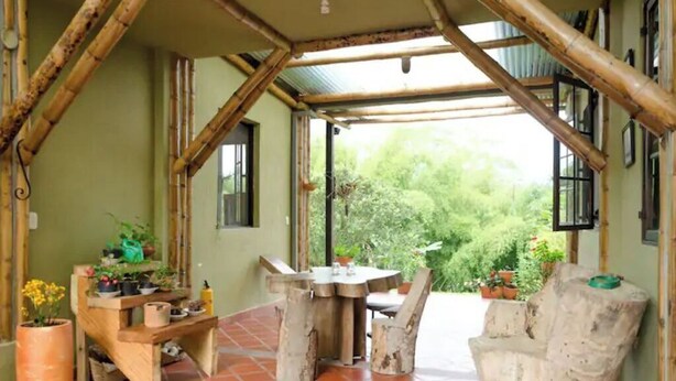 A rustic wooden interior with a dining area, a bench, and potted plants. - Charming coffee region farm escape (Armenia)
