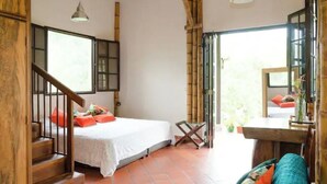A bedroom with a bed, a desk, and a staircase. - Charming coffee region farm escape (Armenia)