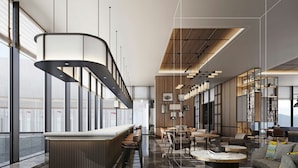 Ein modernes Interieur mit einer langen Bar, Sitzgelegenheiten und großen Fenstern.