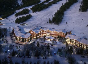 A large lodge with multiple buildings, a ski lift, and a parking area with cars. - Fairfield Inn & Suites By Marriott North Conway (North Conway)