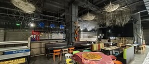 An indoor dining area with tables and chairs, a counter, and hanging decorations. - Gya Yangzhou Economic Development Zone Yangzi Jiang South Road Gaomin Temple Hotel (Yangzhou)