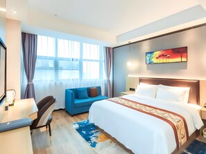 A hotel room with a bed, a desk, a chair, a sofa, and a large window with curtains. - Gya Yangzhou Economic Development Zone Yangzi Jiang South Road Gaomin Temple Hotel (Yangzhou)