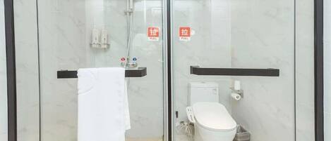 A modern bathroom with a glass enclosure, a white toilet, a shower, and a towel rack.