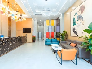 A modern hotel lobby with a reception desk, seating area, and colorful decor. - Gya Yangzhou Economic Development Zone Yangzi Jiang South Road Gaomin Temple Hotel (Yangzhou)
