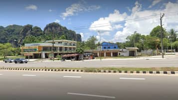 A street view with buildings, a gas station, and a mountain in the background.