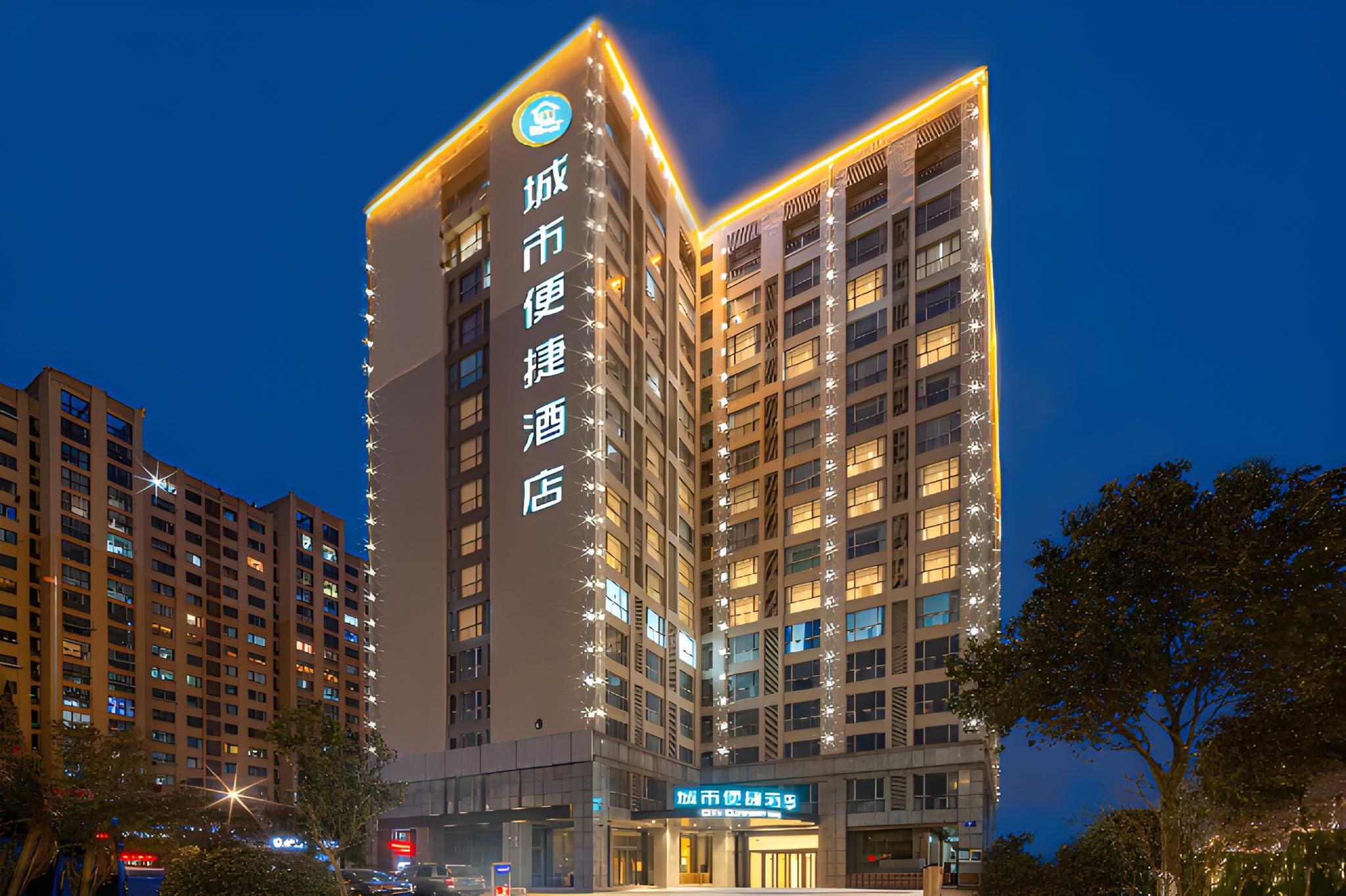 A multi-story hotel building with illuminated signage, a prominent entrance, and a clear view of the surrounding urban environment.