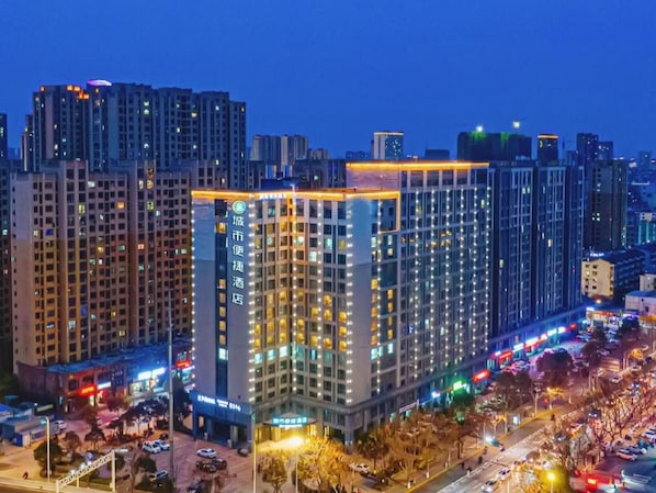 A high-rise building with multiple floors, large windows, and a well-lit facade.
