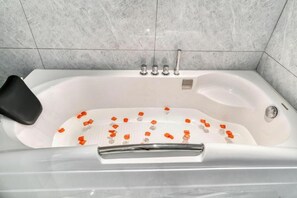 A bathtub with a black seat, a chrome faucet, and a showerhead.