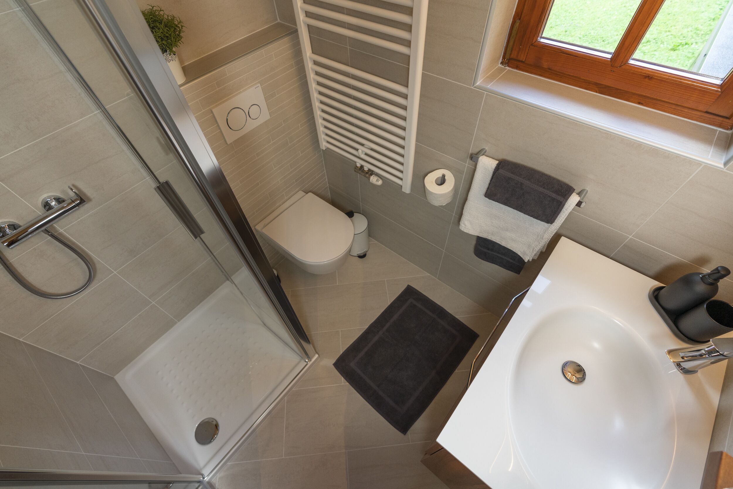 Une salle de bain équipée d’une douche, de toilettes, d’un lavabo et d’un porte-serviettes.
