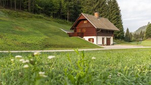 Eine Holzhütte mit geneigtem Dach, einer Veranda und einem Steinfundament.