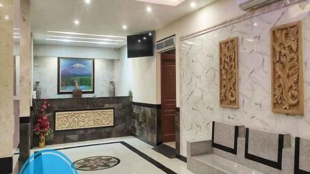 A hotel lobby with a reception desk, a mounted TV, and a marble floor. - LUMBA LUMBA INN WARU (Waru)