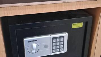 A secure safe with a combination dial and keypad, a warning label, and a metal door.