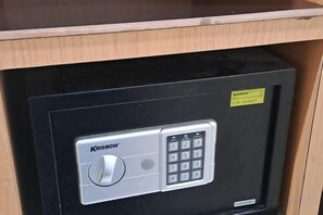 Una caja fuerte segura con un dial de combinación y teclado, una etiqueta de advertencia y una puerta de metal.