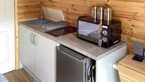 Uma cozinha compacta com máquina de lavar louça embutida, torradeira e chaleira na bancada.
